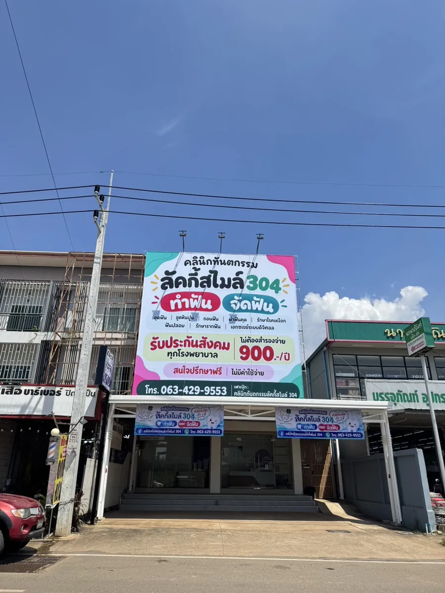 หน้าคลินิกลัคกี้สไมล์ 304 มีป้ายใหญ่ชื่อคลินิกด้านบนอาคาร